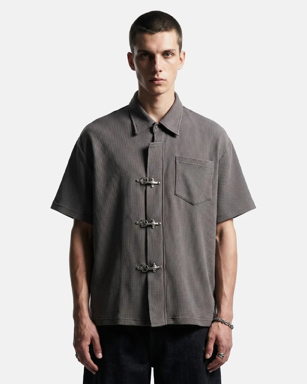Men's grey waffle-textured short-sleeve shirt with metal clasps and chest pocket