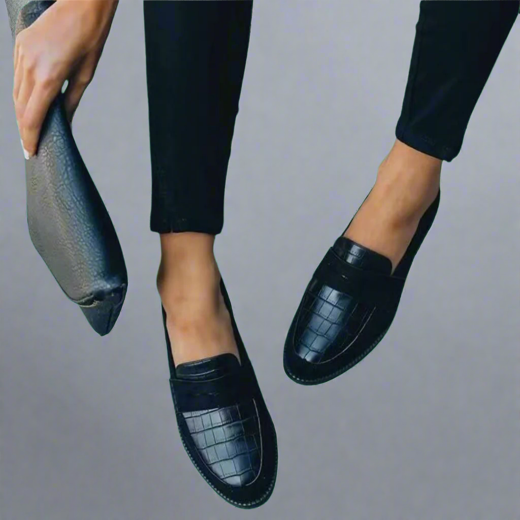 Black slip-on loafers with textured vamp panels and flat soles