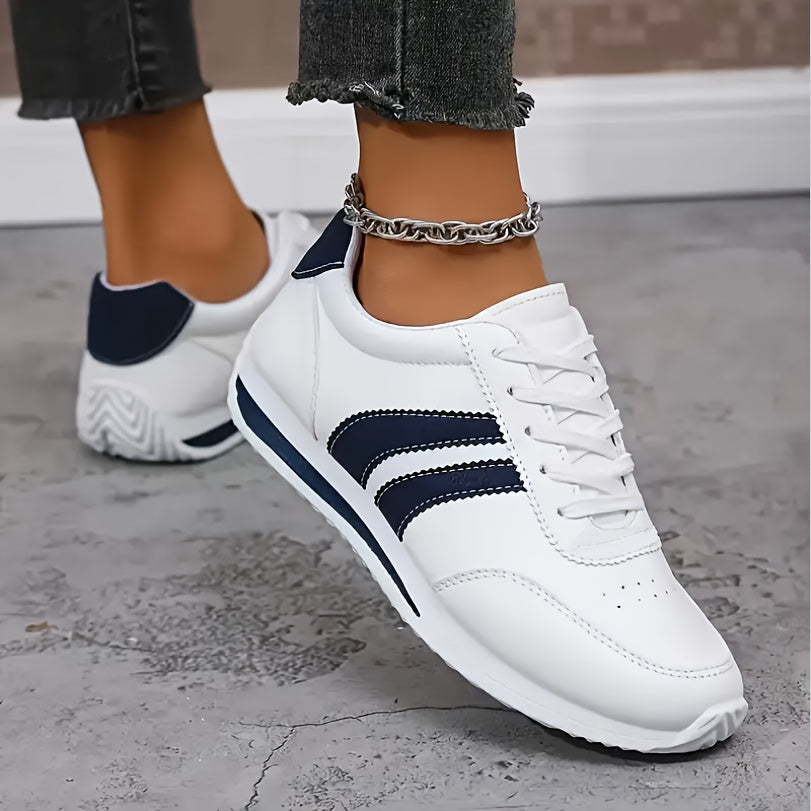 Women's white lace-up sneakers with navy side stripes and flat soles