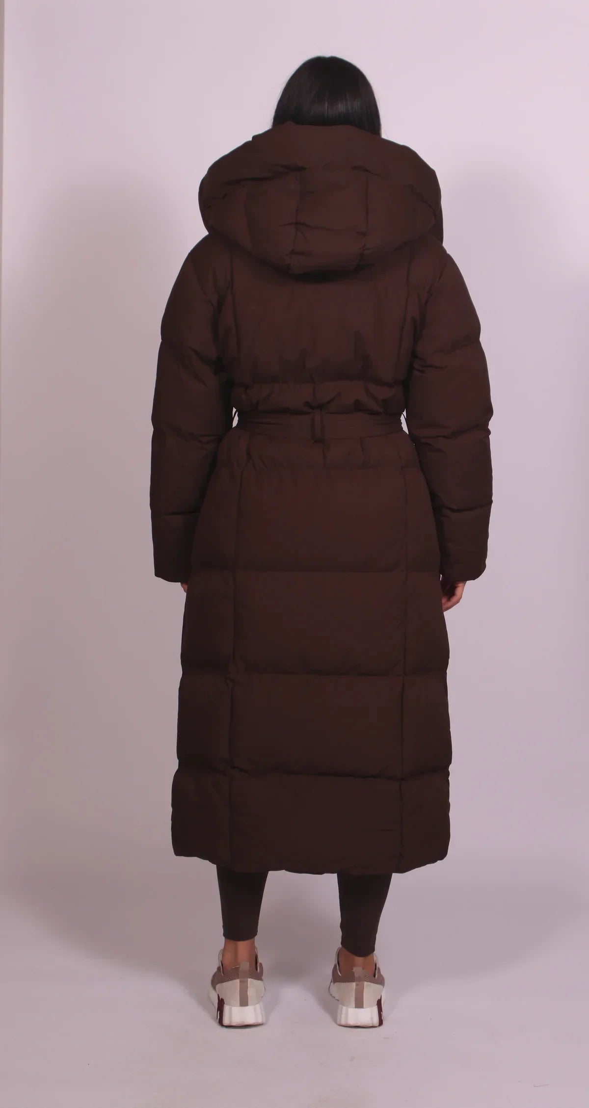 Women's longline hooded puffer coat with a belted waist and front zip
