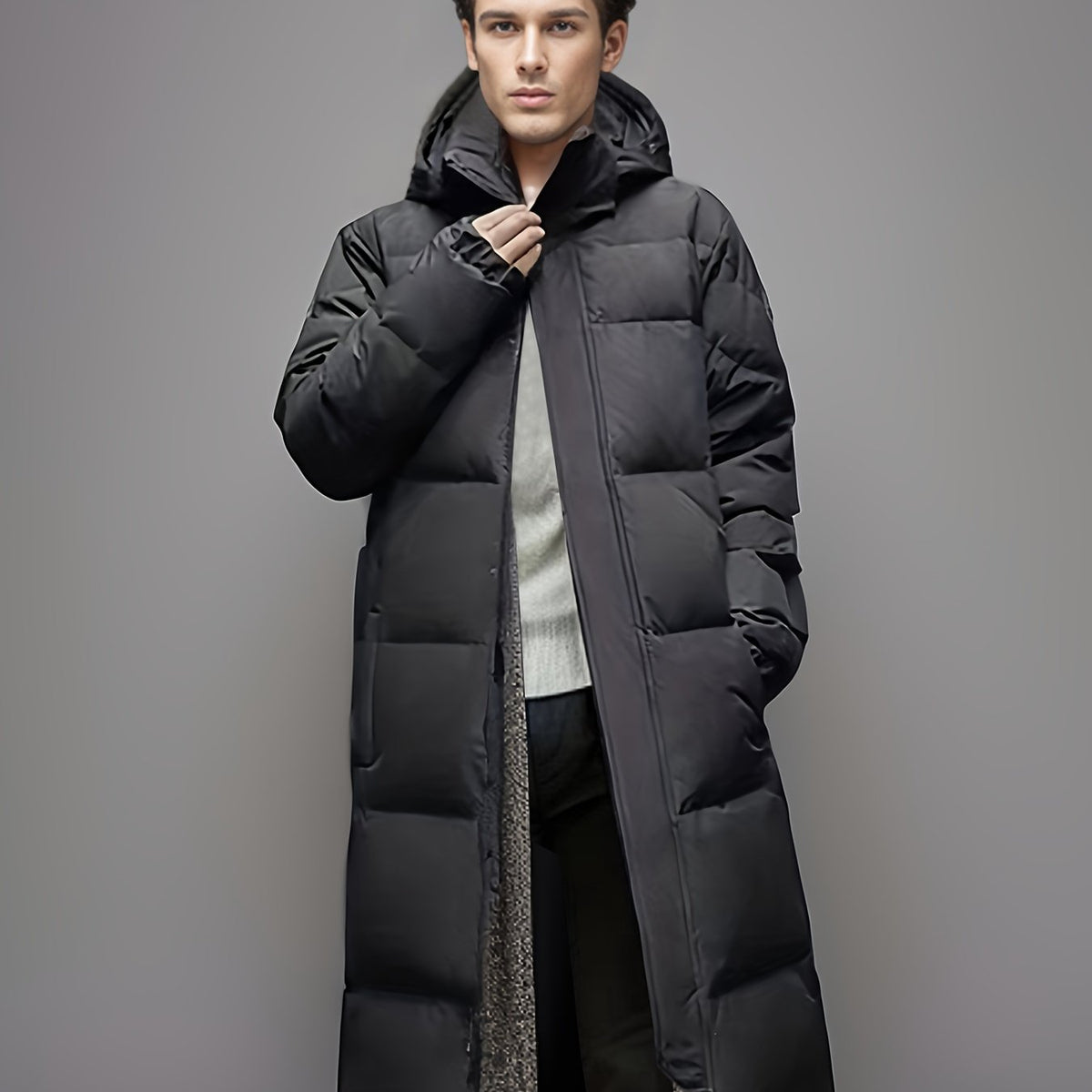 Men's black long hooded puffer coat with quilted panels and front zip