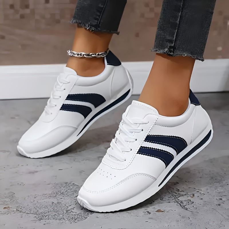 Women's white lace-up sneakers with navy side stripes and flat soles