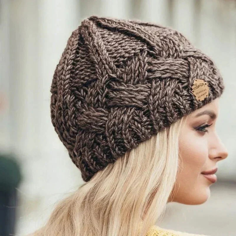Women's chunky cable knit beanie hat with turn-up cuff and front label detail