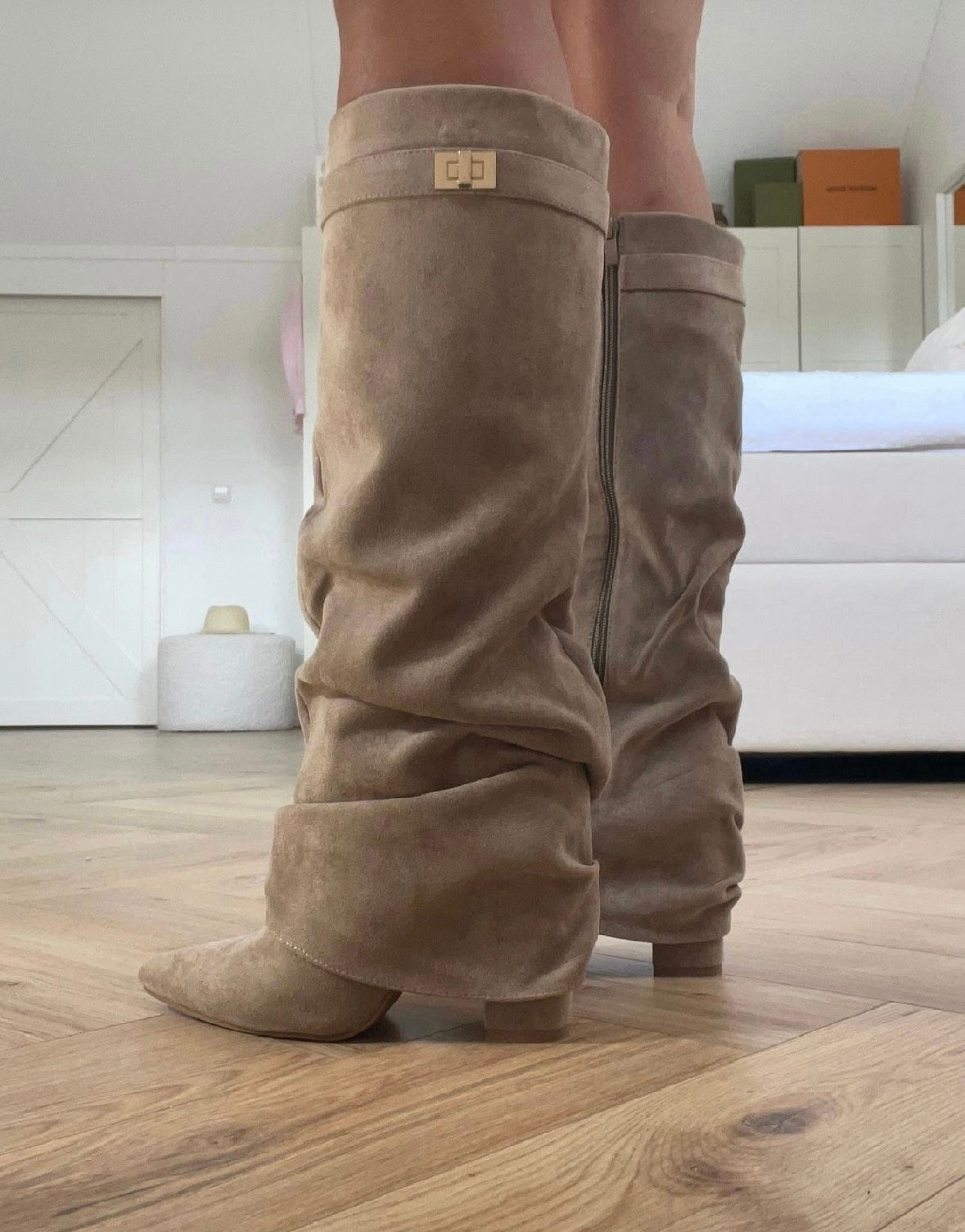 Beige slouch knee-high boots with pointed toes, low heels and buckle strap detail