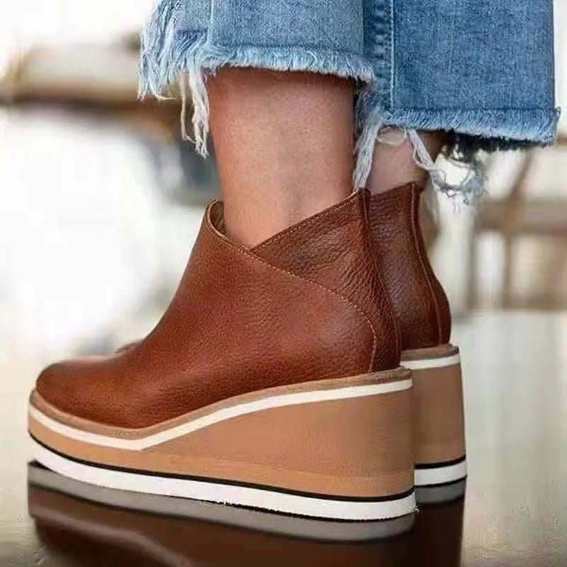 Women's ankle boots with rounded toes, side zips and raised wedge-style soles