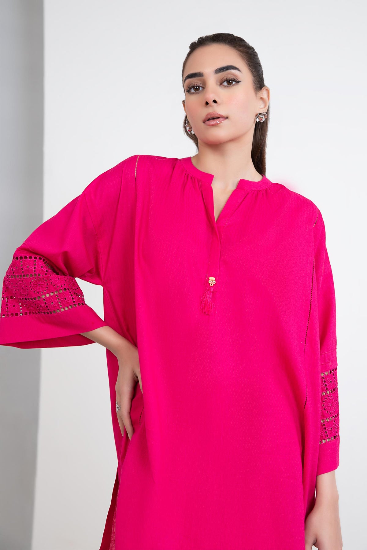 Women's bright pink two-piece tunic suit with lace-trimmed sleeves and matching trousers
