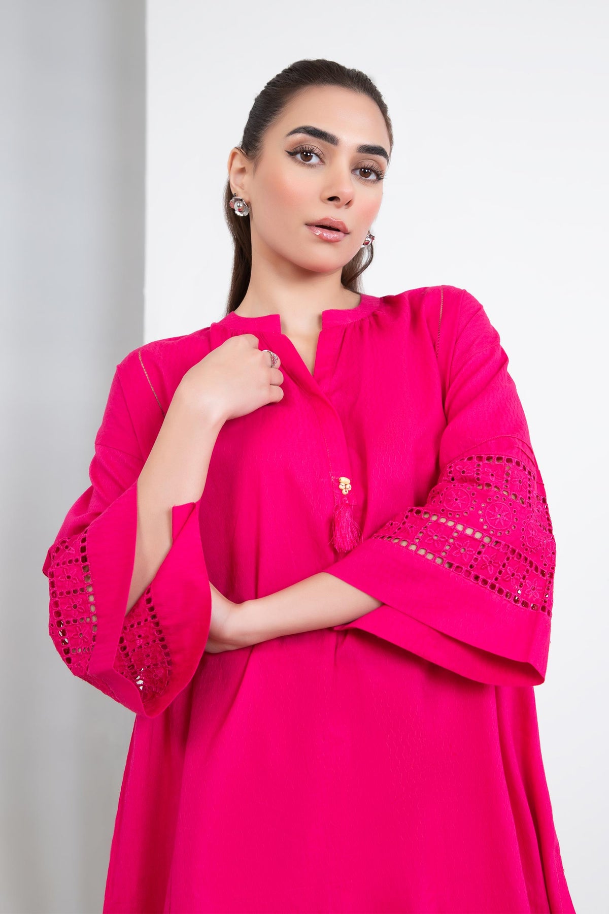 Women's bright pink two-piece tunic suit with lace-trimmed sleeves and matching trousers