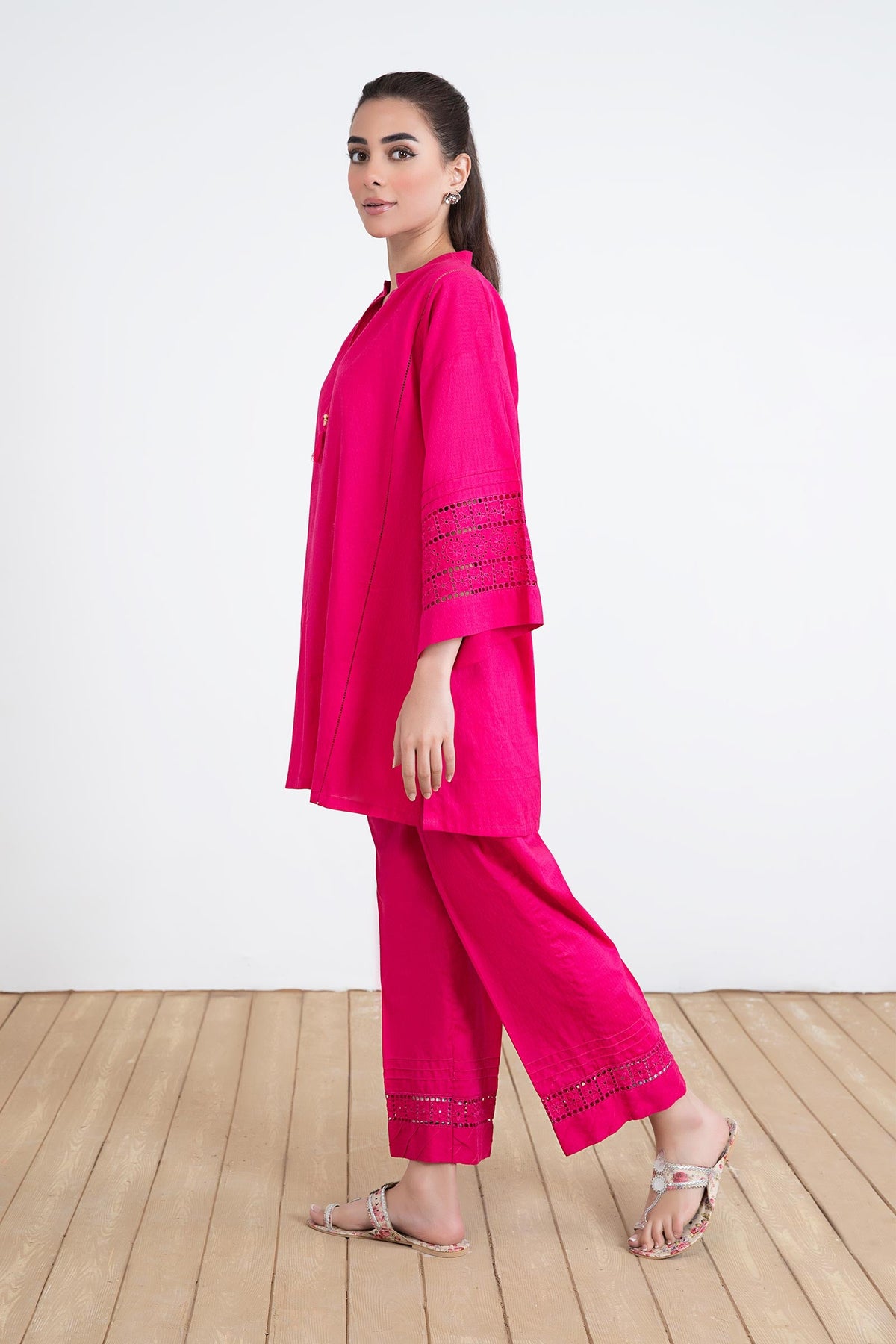 Women's bright pink two-piece tunic suit with lace-trimmed sleeves and matching trousers