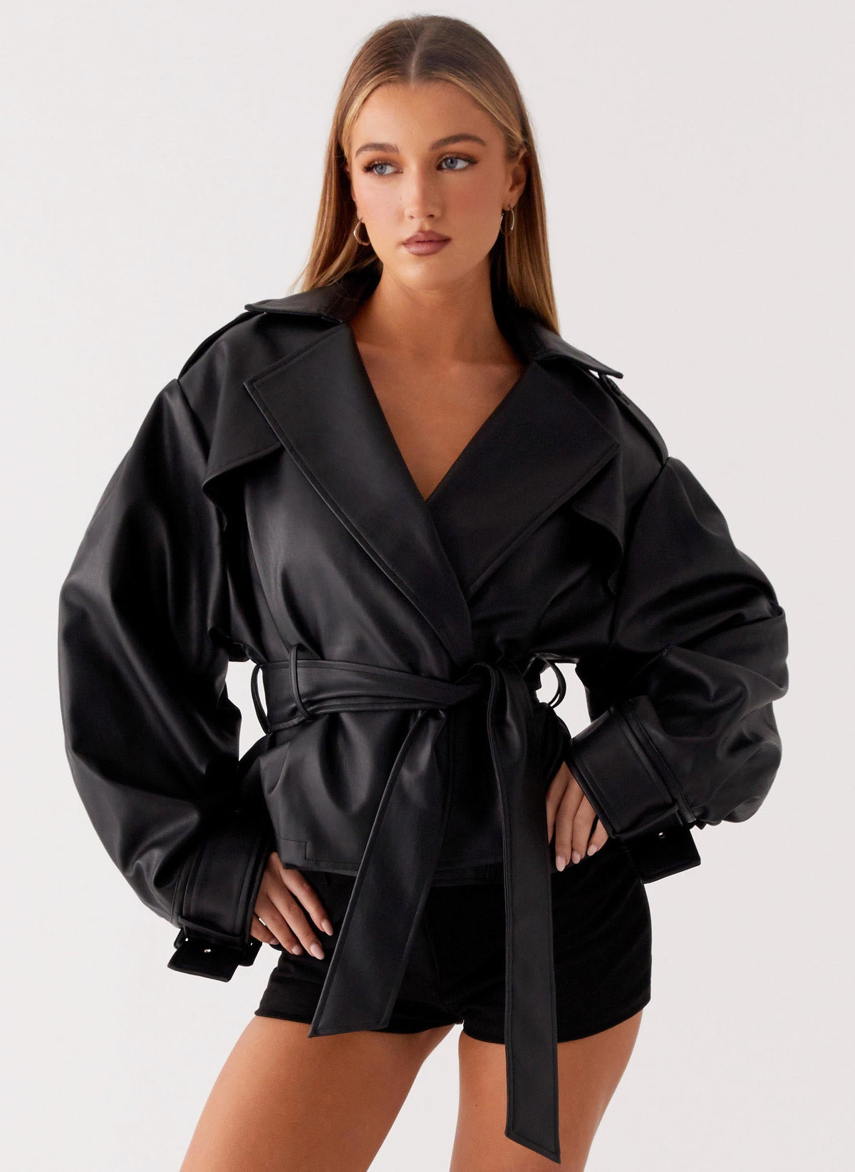 Women's black belted trench jacket with wide lapels and long sleeves