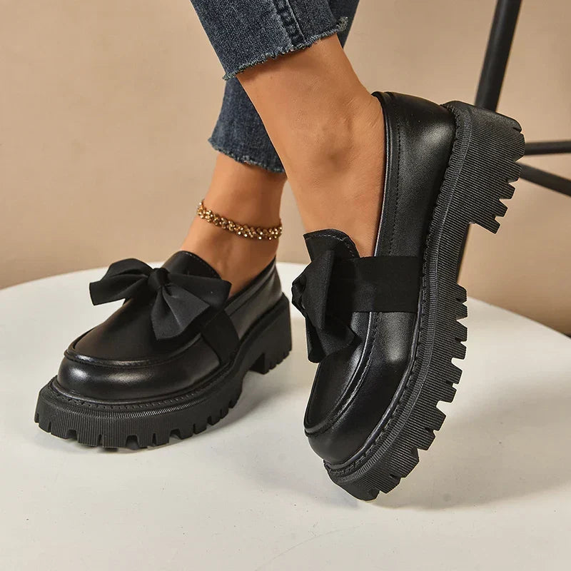 Women's glossy chunky loafers with large bows and black lug soles