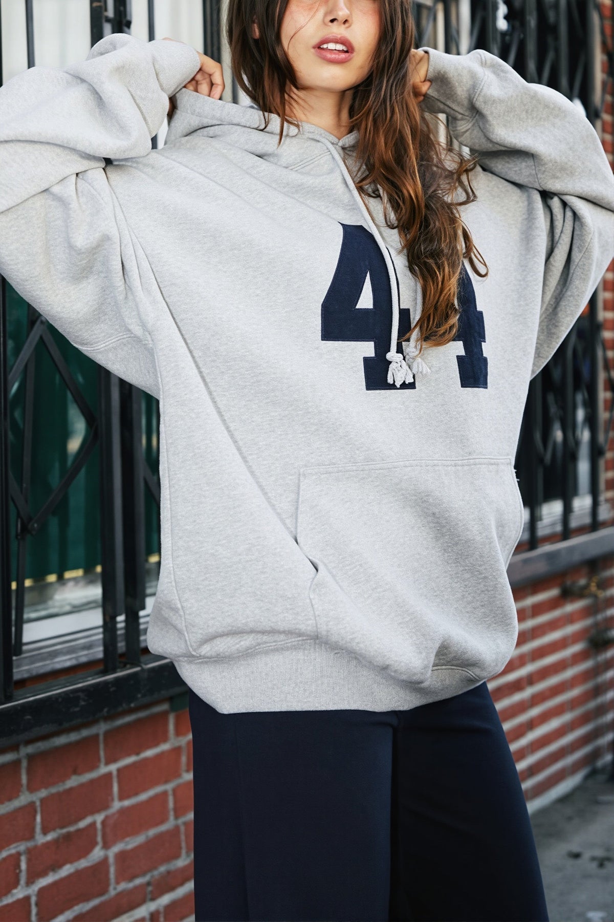 Women's oversized hooded pullover with long sleeves, pouch pocket and number graphic