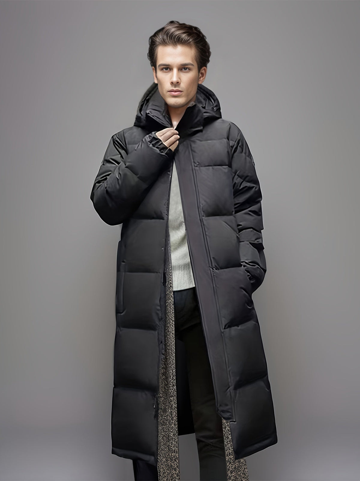 Men's black long hooded puffer coat with quilted panels and front zip