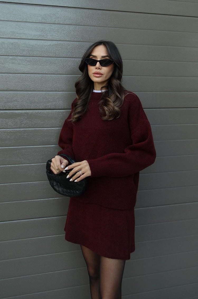 Woman wearing a plain knitted jumper and mini skirt set