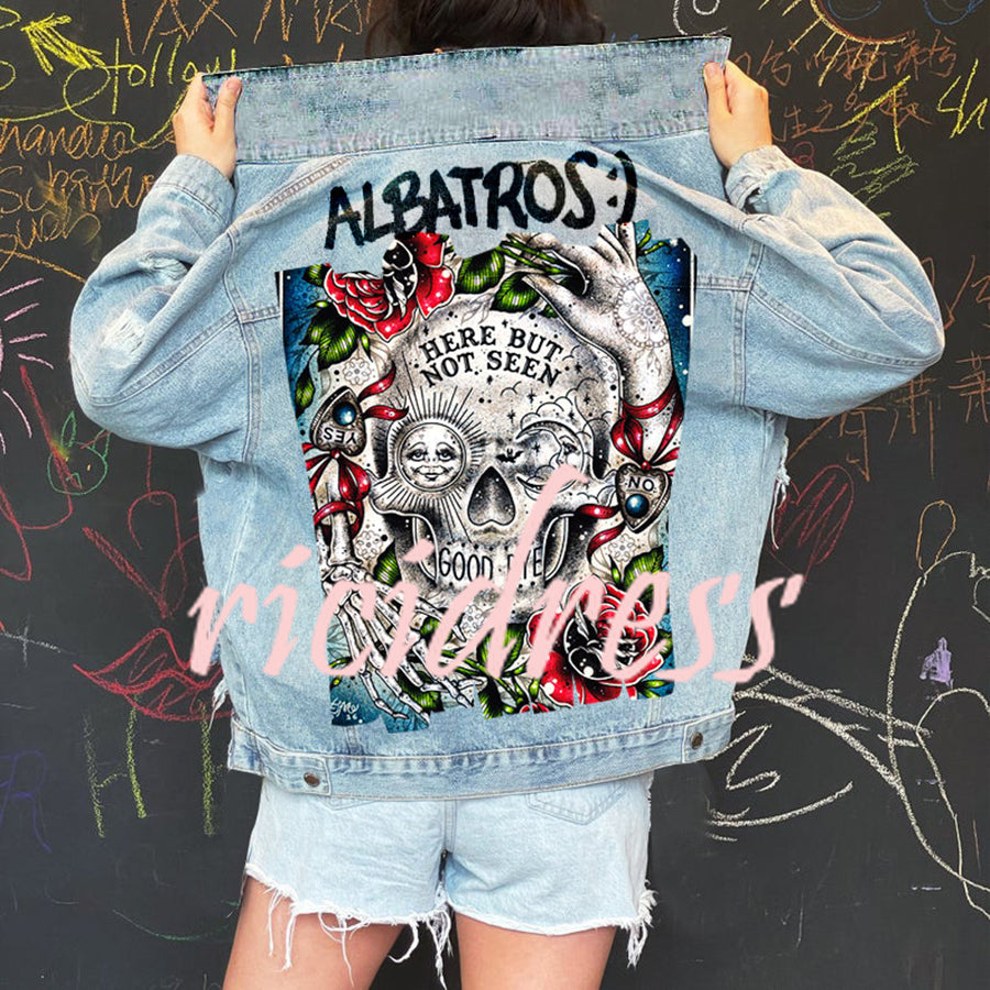 Women's light blue denim jacket with a large skull and rose graphic on the back