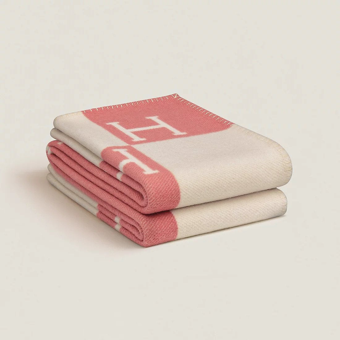 Folded rectangular throw blanket with contrasting block pattern and letter motifs