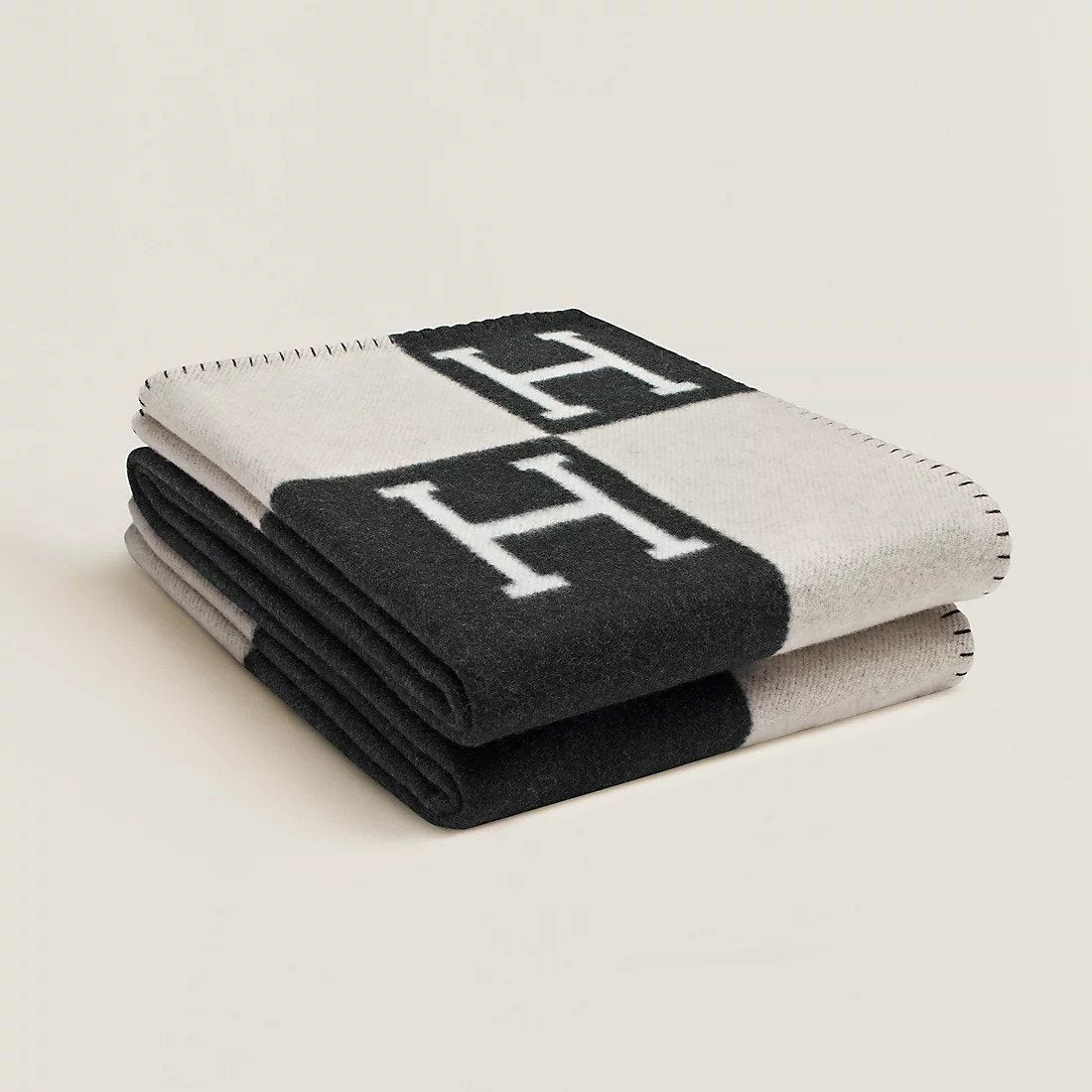 Folded rectangular throw blanket with contrasting block pattern and letter motifs