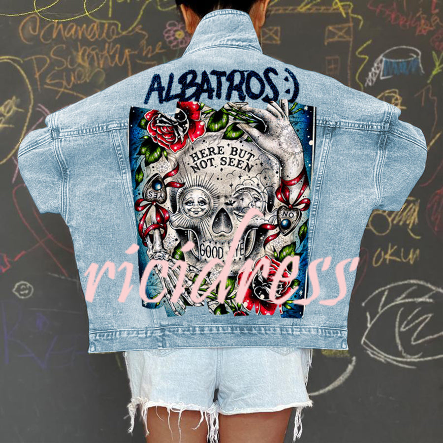Women's light blue denim jacket with a large skull and rose graphic on the back