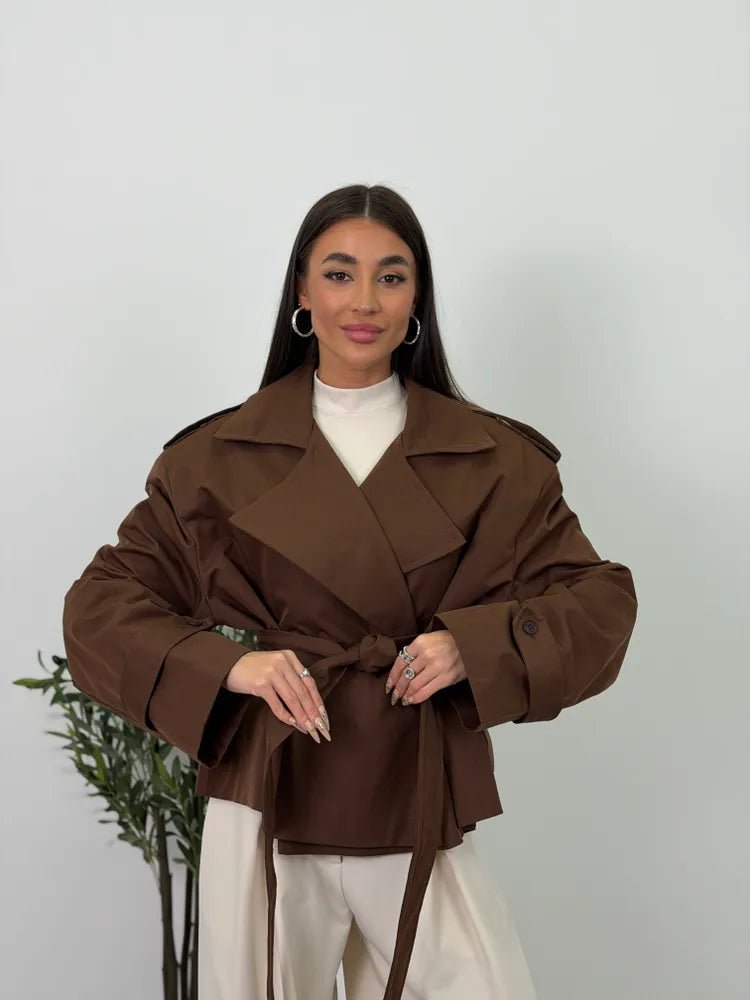Women's brown cropped trench coat with lapels, tie belt and long sleeves
