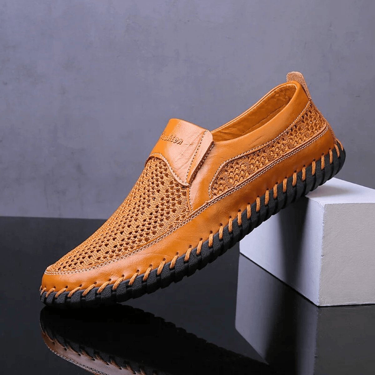 Men's textured slip-on loafer with perforated panels, stitched trim and black flat sole