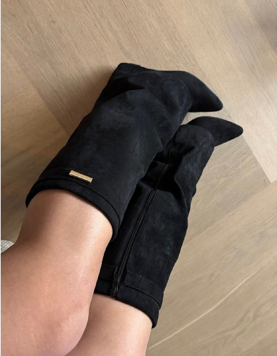 Women's black over-the-knee boots with pointed toes, wedge heels, side zips and metallic trim