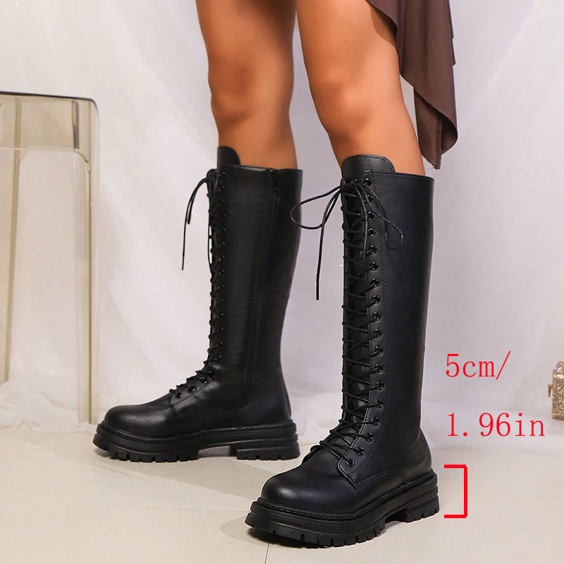Black knee-high lace-up platform boots with round toes and lugged soles