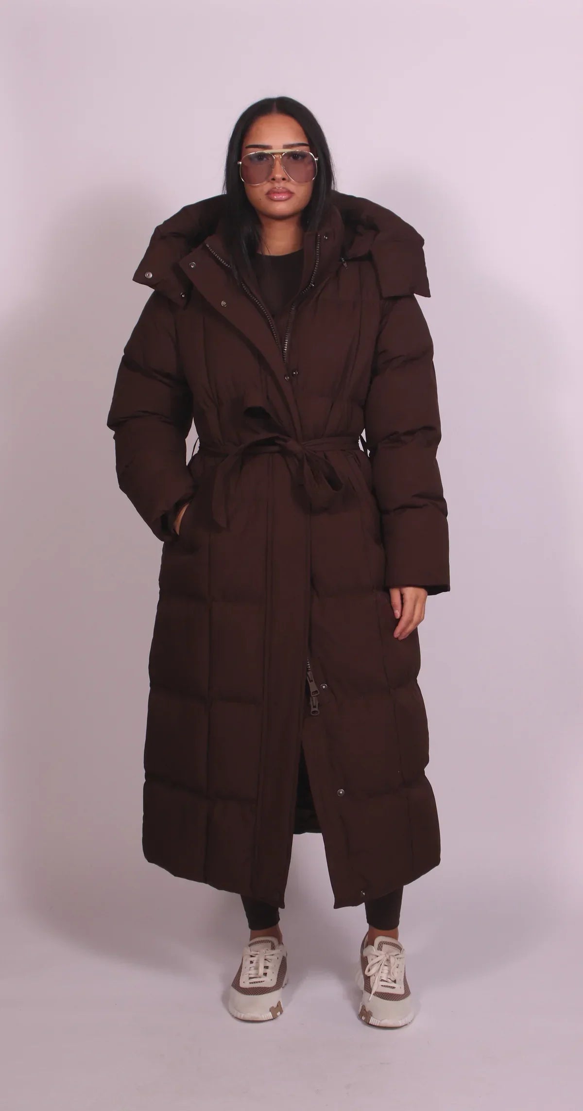 Women's longline hooded puffer coat with a belted waist and front zip