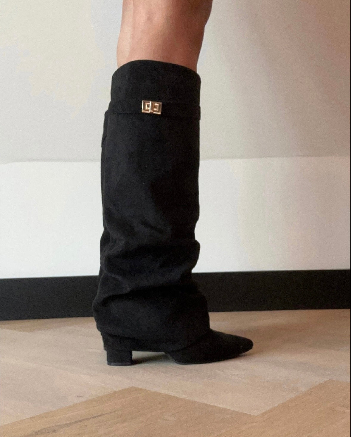 Women's black slouch knee-high boots with pointed toes, low heels and buckle trim