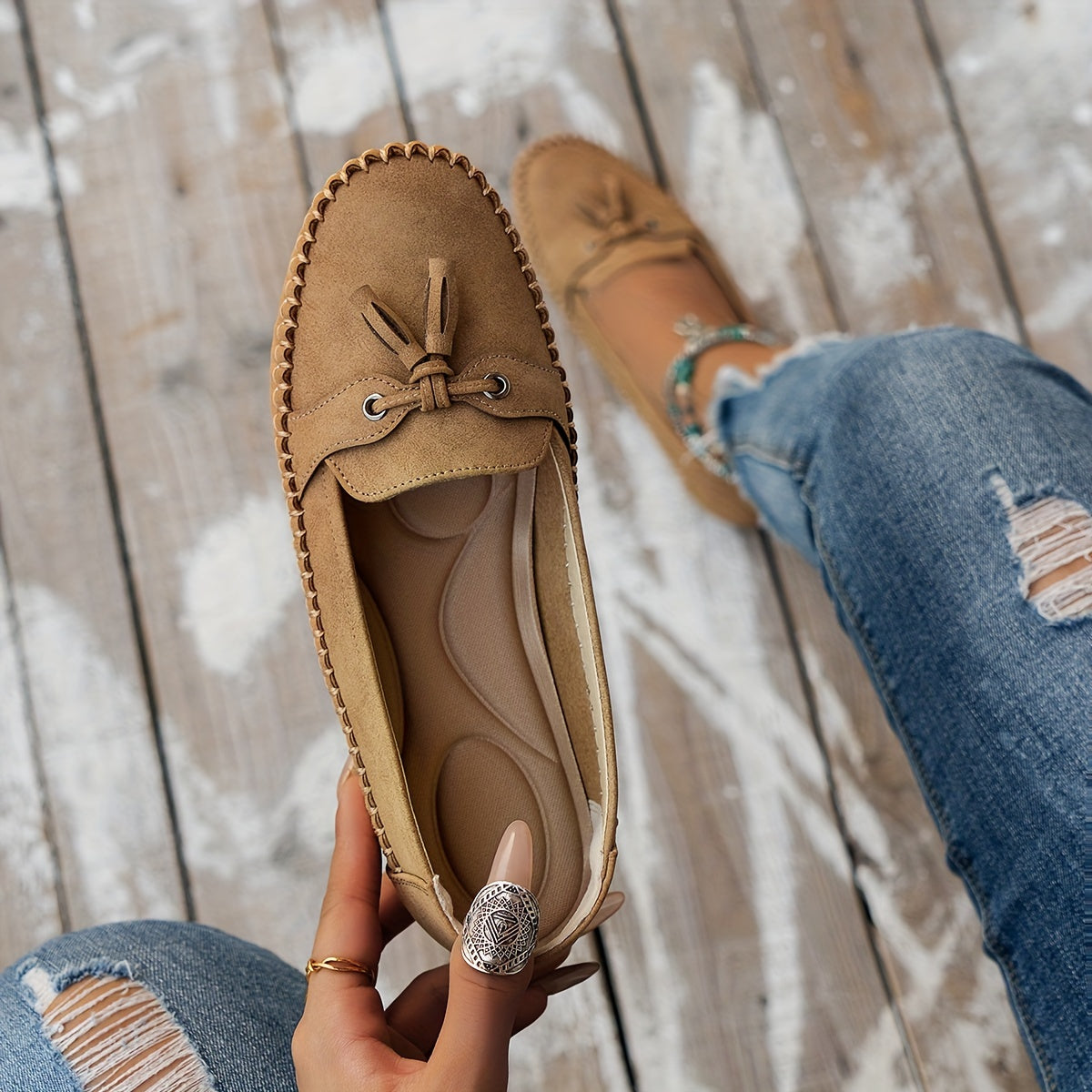 Women's flat loafers with front tassels, decorative lacing and stitched edging
