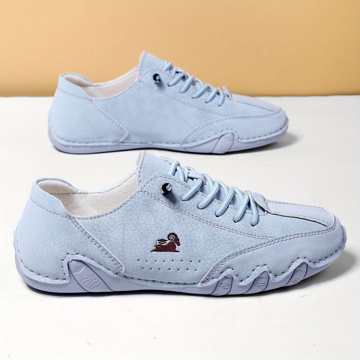 Women's low-profile lace-up trainers with rounded toes and stitched panels