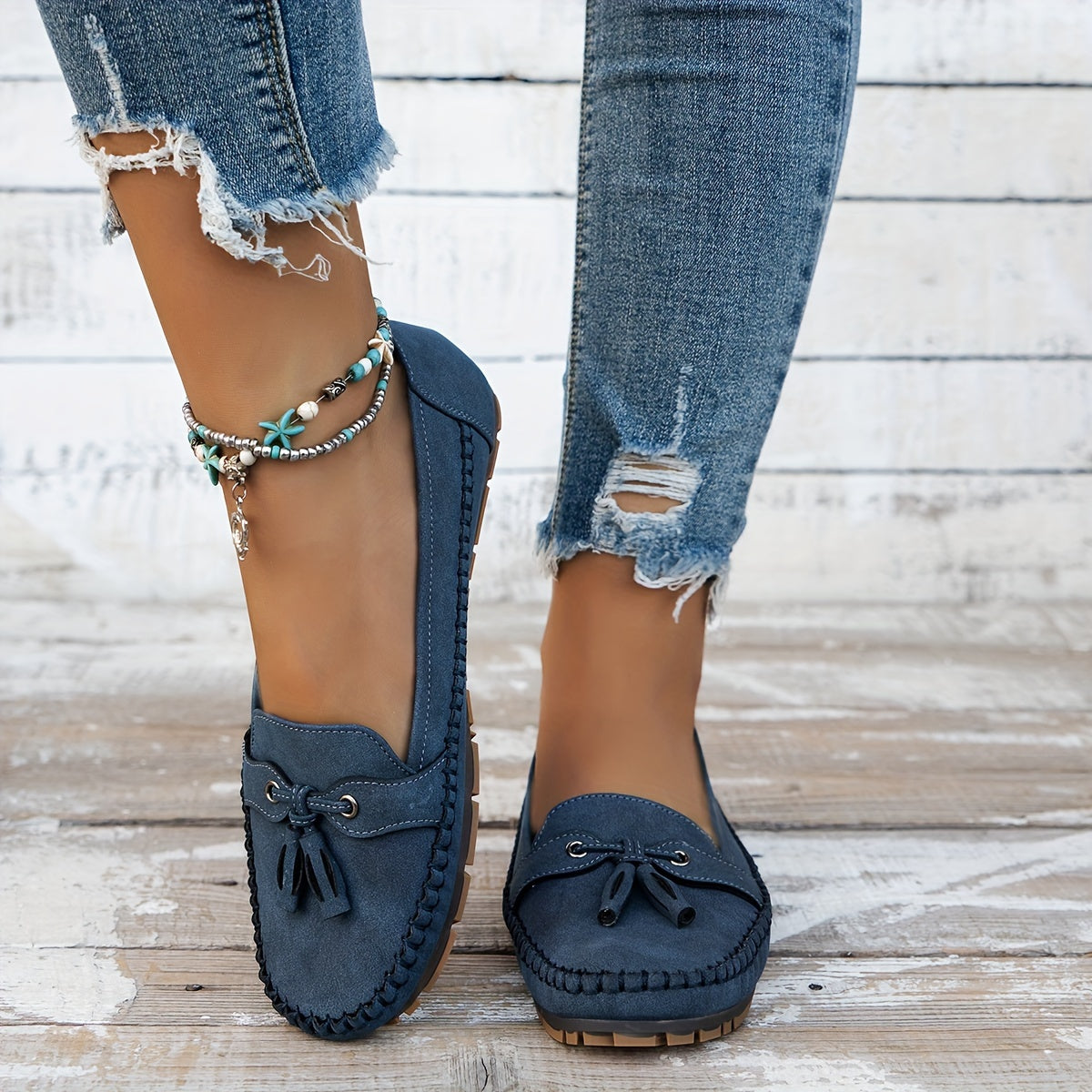 Women's flat loafers with front tassels, decorative lacing and stitched edging