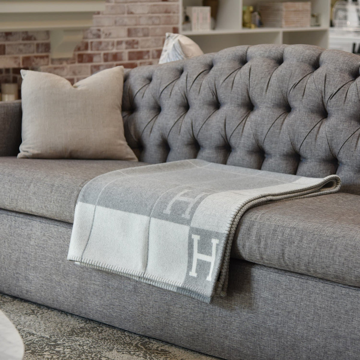 Folded rectangular throw blanket with contrasting block pattern and letter motifs