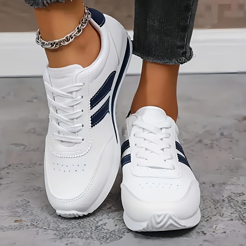 Women's white lace-up sneakers with navy side stripes and flat soles