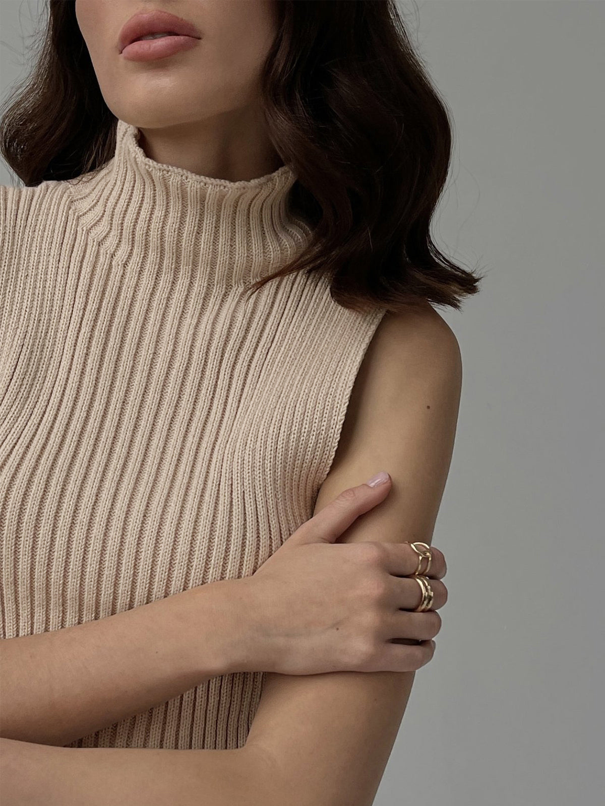 Women's ribbed sleeveless knit top with high neckline and fitted shape