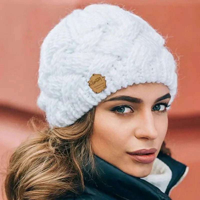 Women's chunky cable knit beanie hat with turn-up cuff and front label detail