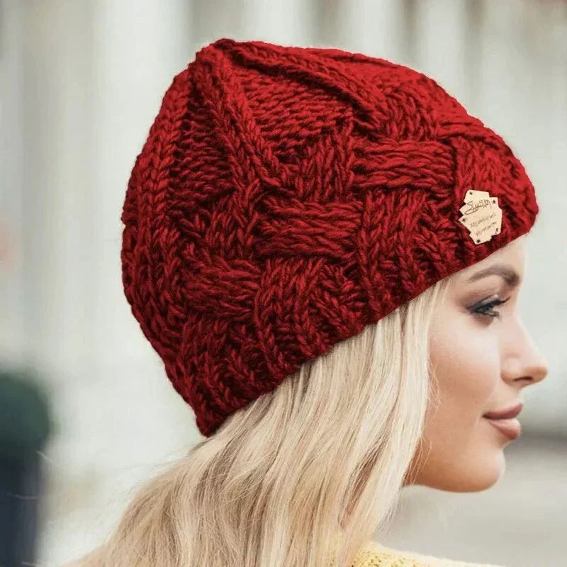 Women's chunky cable knit beanie hat with turn-up cuff and front label detail