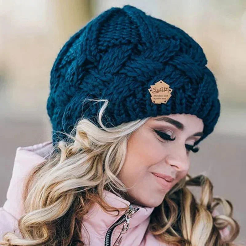 Women's chunky cable knit beanie hat with turn-up cuff and front label detail