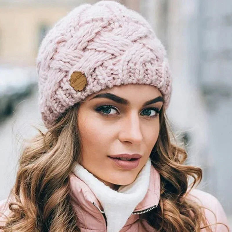 Women's chunky cable knit beanie hat with turn-up cuff and front label detail