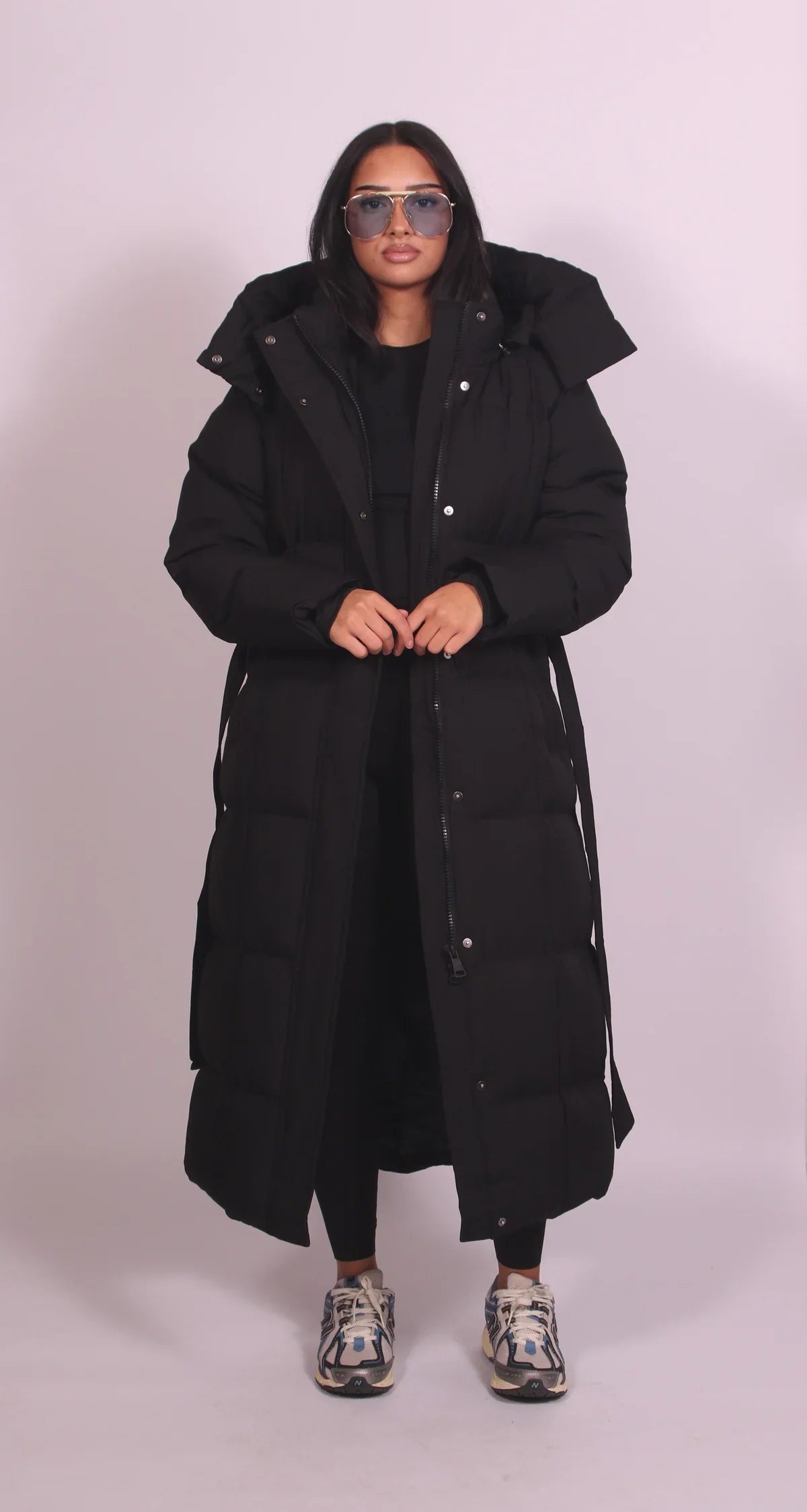 Women's longline hooded puffer coat with a belted waist and front zip