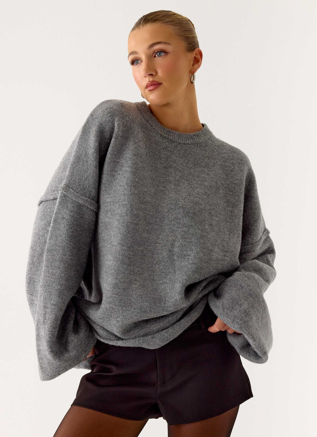Women's grey oversized knit sweater with crew neck and flared sleeves