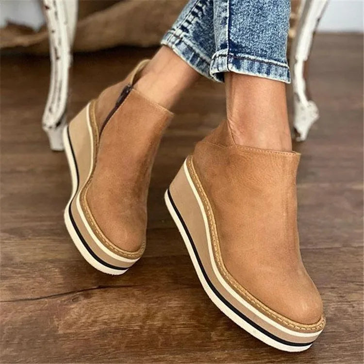 Women's ankle boots with rounded toes, side zips and raised wedge-style soles