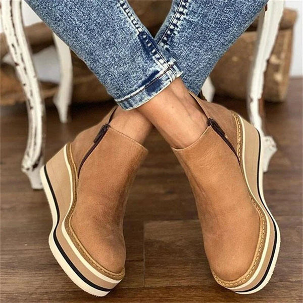 Women's ankle boots with rounded toes, side zips and raised wedge-style soles
