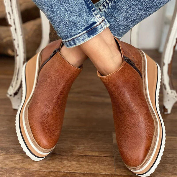 Women's ankle boots with rounded toes, side zips and raised wedge-style soles