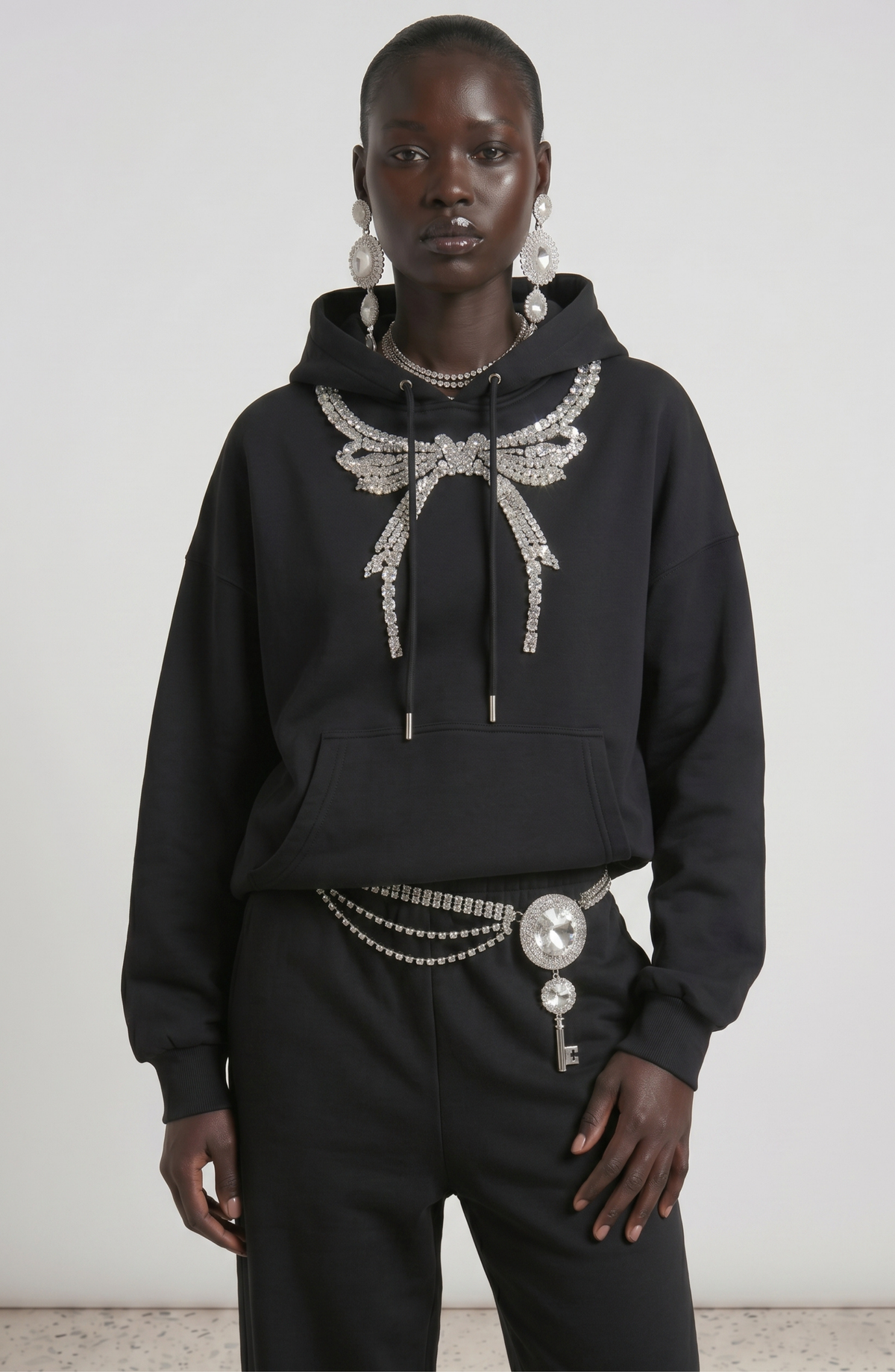 Women's dark hooded hoodie with embellished wing and bow motif, long sleeves and kangaroo pocket