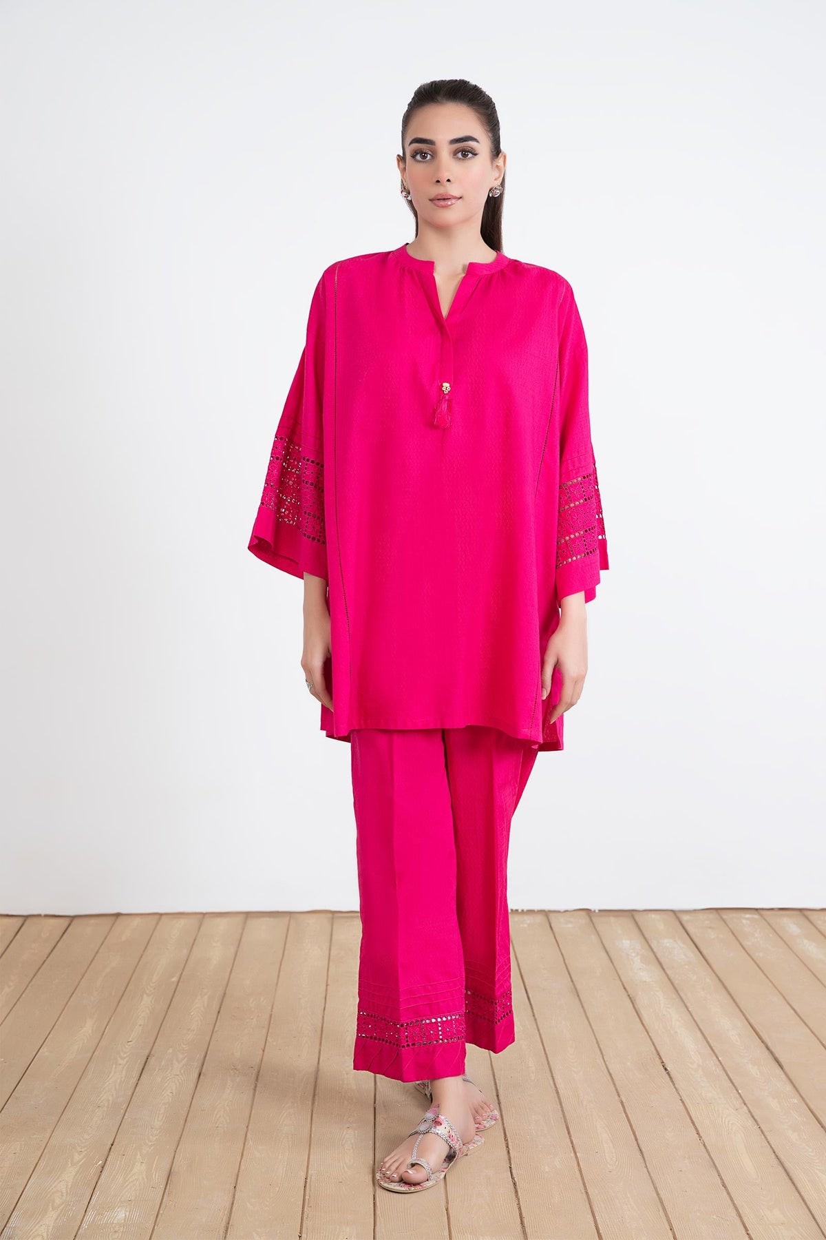 Women's bright pink two-piece tunic suit with lace-trimmed sleeves and matching trousers