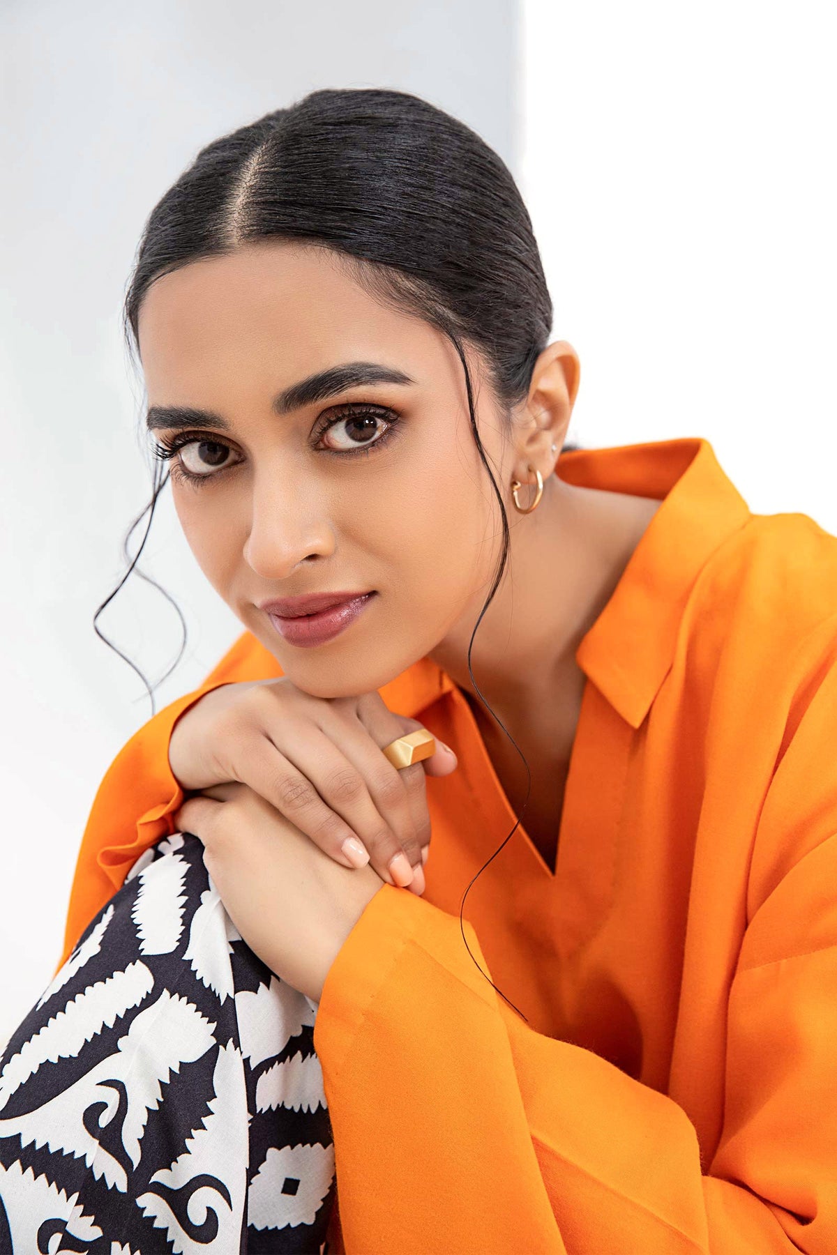 Woman wearing an orange long-sleeve tunic with patterned trousers