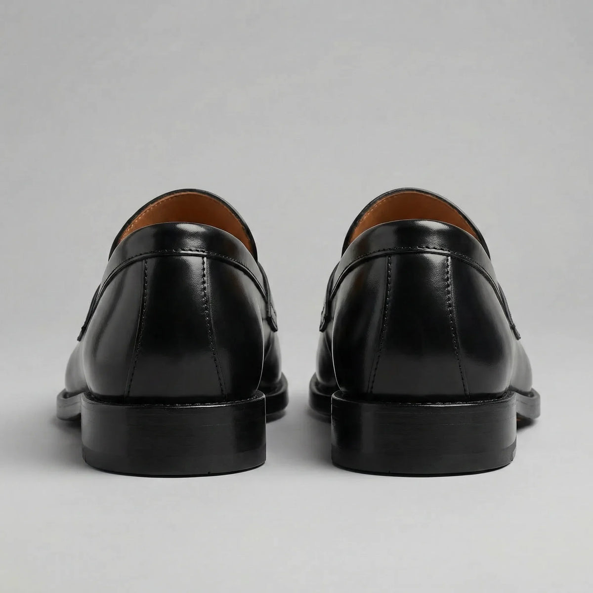 Men's black penny loafers with polished finish and low block heels