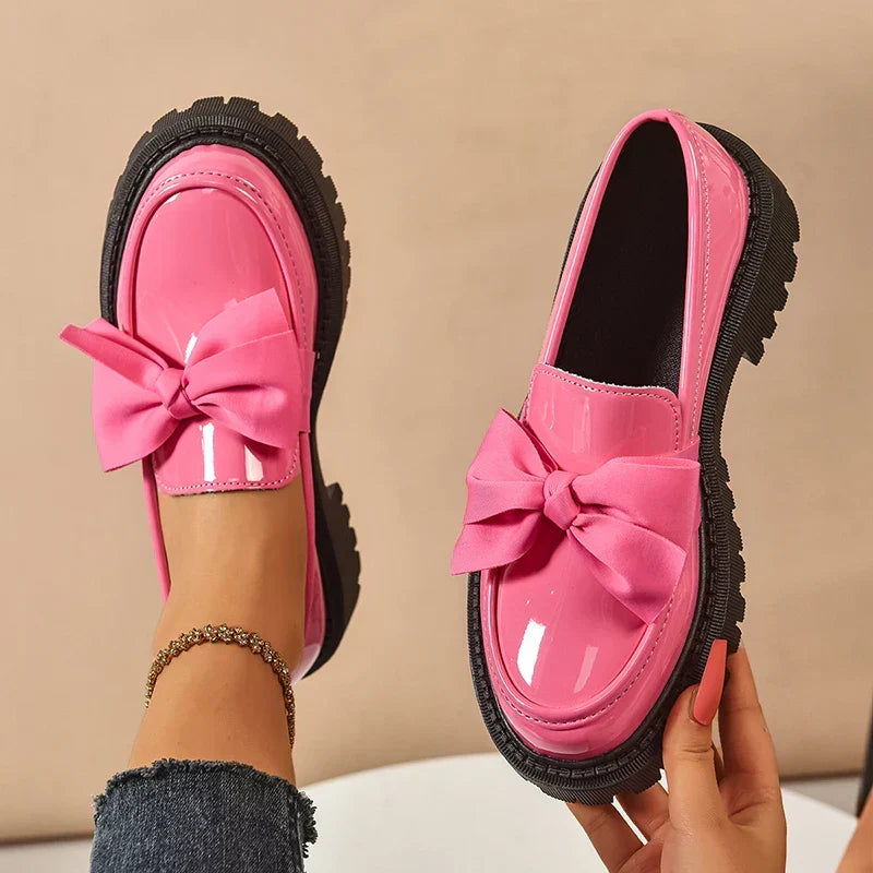 Women's glossy chunky loafers with large bows and black lug soles