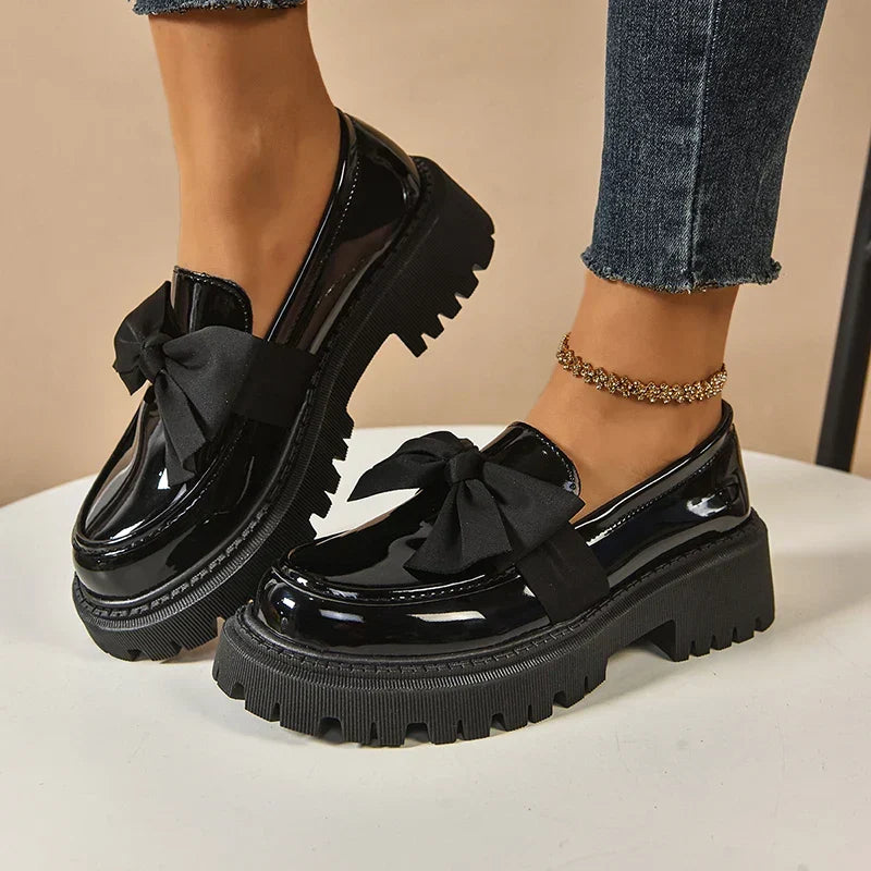 Women's glossy chunky loafers with large bows and black lug soles