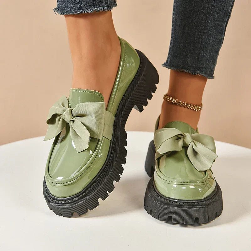 Women's glossy chunky loafers with large bows and black lug soles