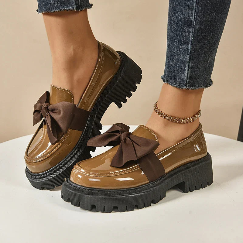 Women's glossy chunky loafers with large bows and black lug soles